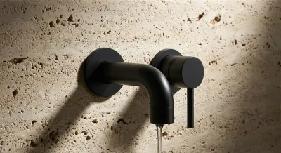 Détail minimaliste d'une robinetterie noire sur fond beige