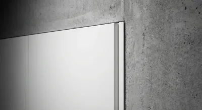 Gros plan sur la finition entre un meuble de cuisine blanc et un mur gris