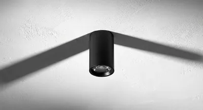 Gros plan d'un spot LED cylindrique noir élégant fixé directement sur le plafond.