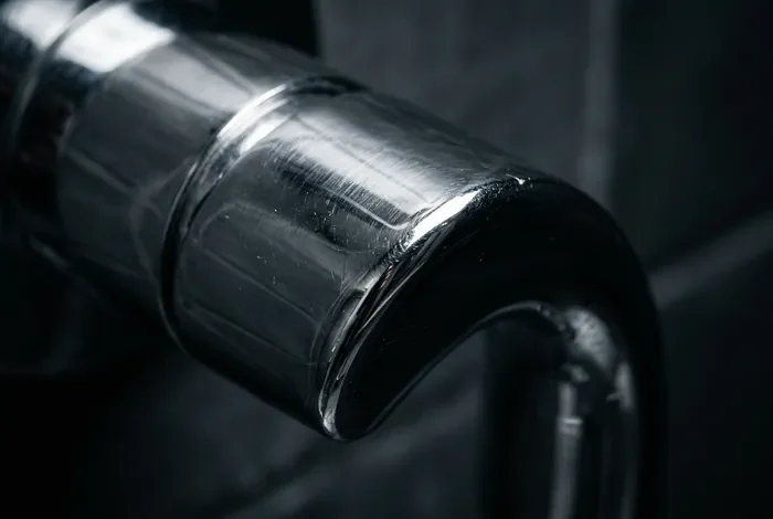 Gros plan macro sur la poignée d'un mitigeur de douche en chrome