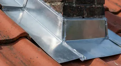 Zoom sur un abergement de cheminée en zinc neuf et étanche.